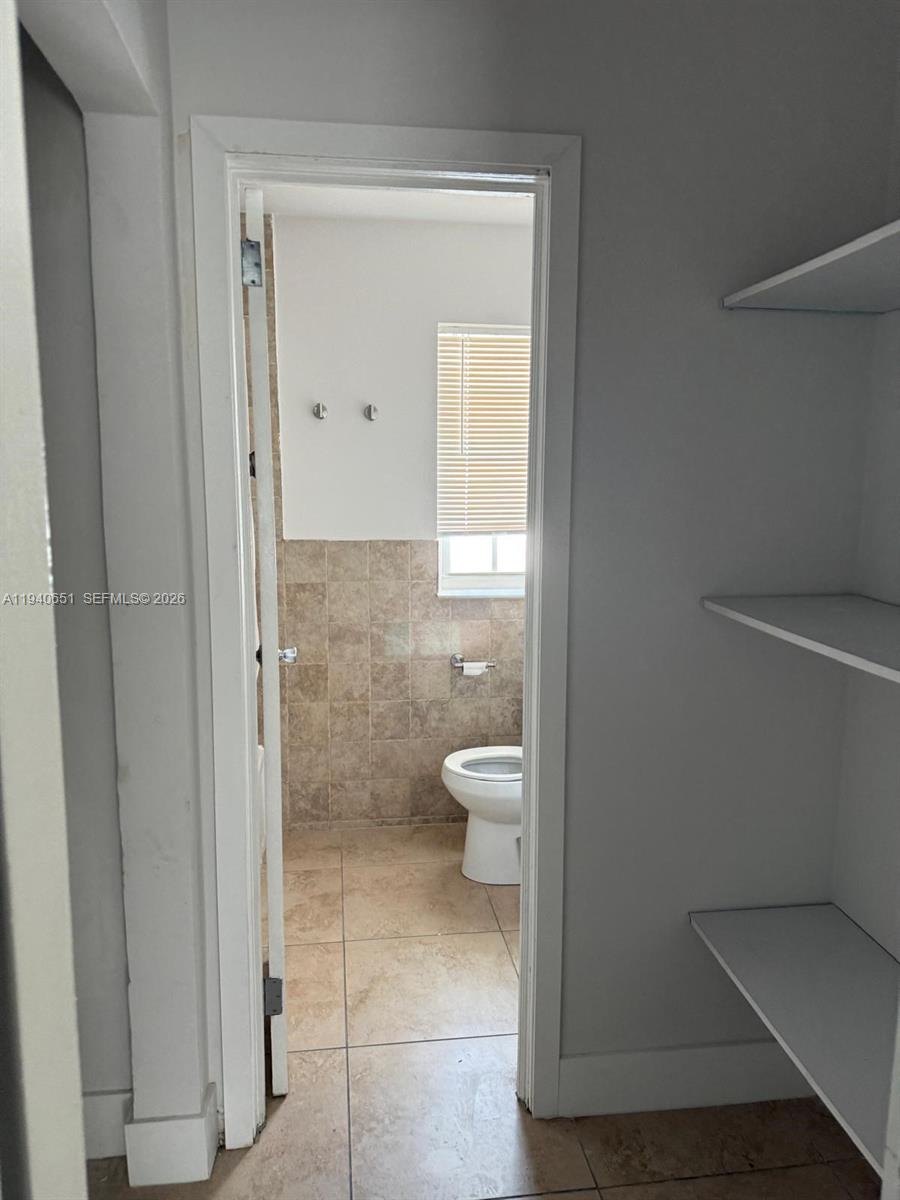 7611 Harding Avenue, Unit 5 Miami Beach, FL 33141 - Photo 6 of 15 a bathroom with a granite countertop toilet and a sink
