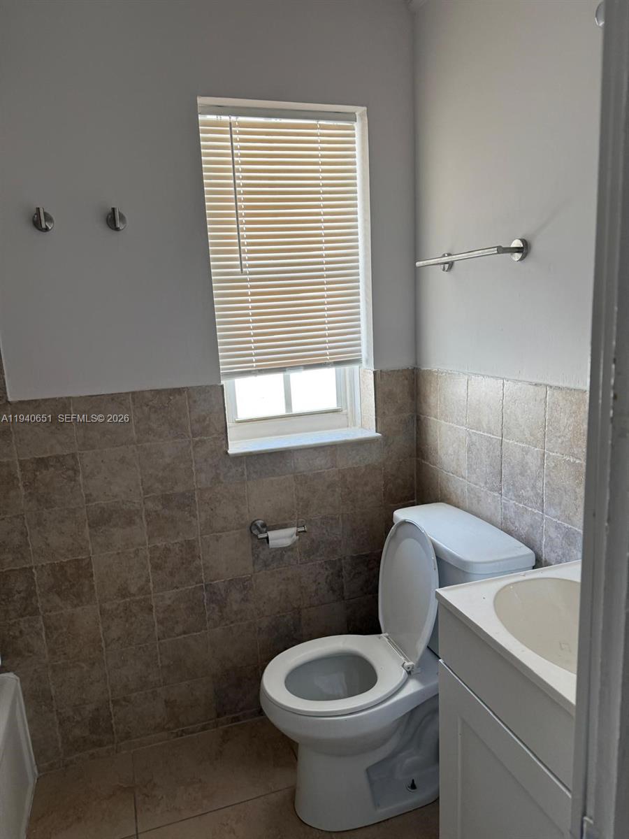 7611 Harding Avenue, Unit 5 Miami Beach, FL 33141 - Photo 7 of 15 a bathroom with a toilet sink and mirror