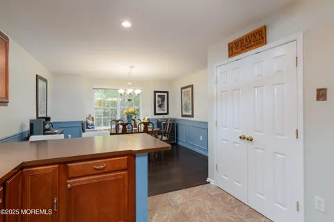 a view of a kitchen with kitchen island a counter top space a sink a refrigerator and a view of living room