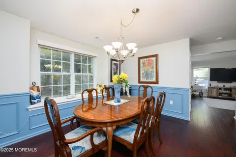 a dining room with furniture a large window and wooden floor