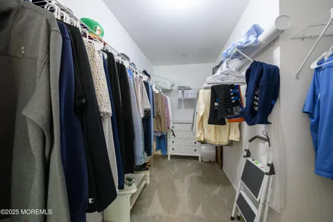 a view of walk in closet with clothes and shoes