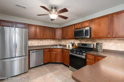 a kitchen with stainless steel appliances granite countertop a refrigerator stove top oven a sink and dishwasher