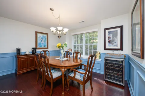 a dining room with furniture a chandelier and wooden floor
