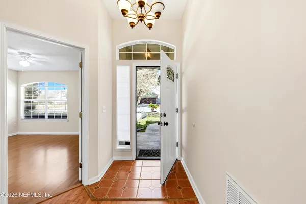 a view of a hallway view with wooden floor and a living room