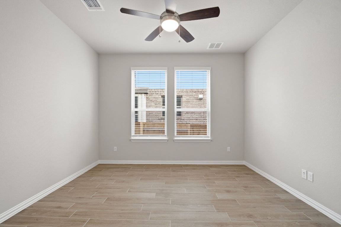 1009 Calendula Trail Georgetown, TX 78628 - Photo 12 of 31 an empty room with chandelier fan and windows