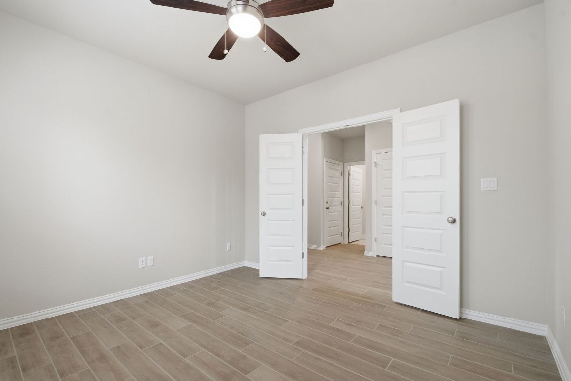 1009 Calendula Trail Georgetown, TX 78628 - Photo 13 of 31 an empty room with wooden floor cabinet and windows