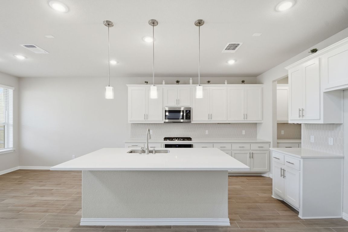 1009 Calendula Trail Georgetown, TX 78628 - Photo 8 of 31 a kitchen with a sink stainless steel appliances and cabinets