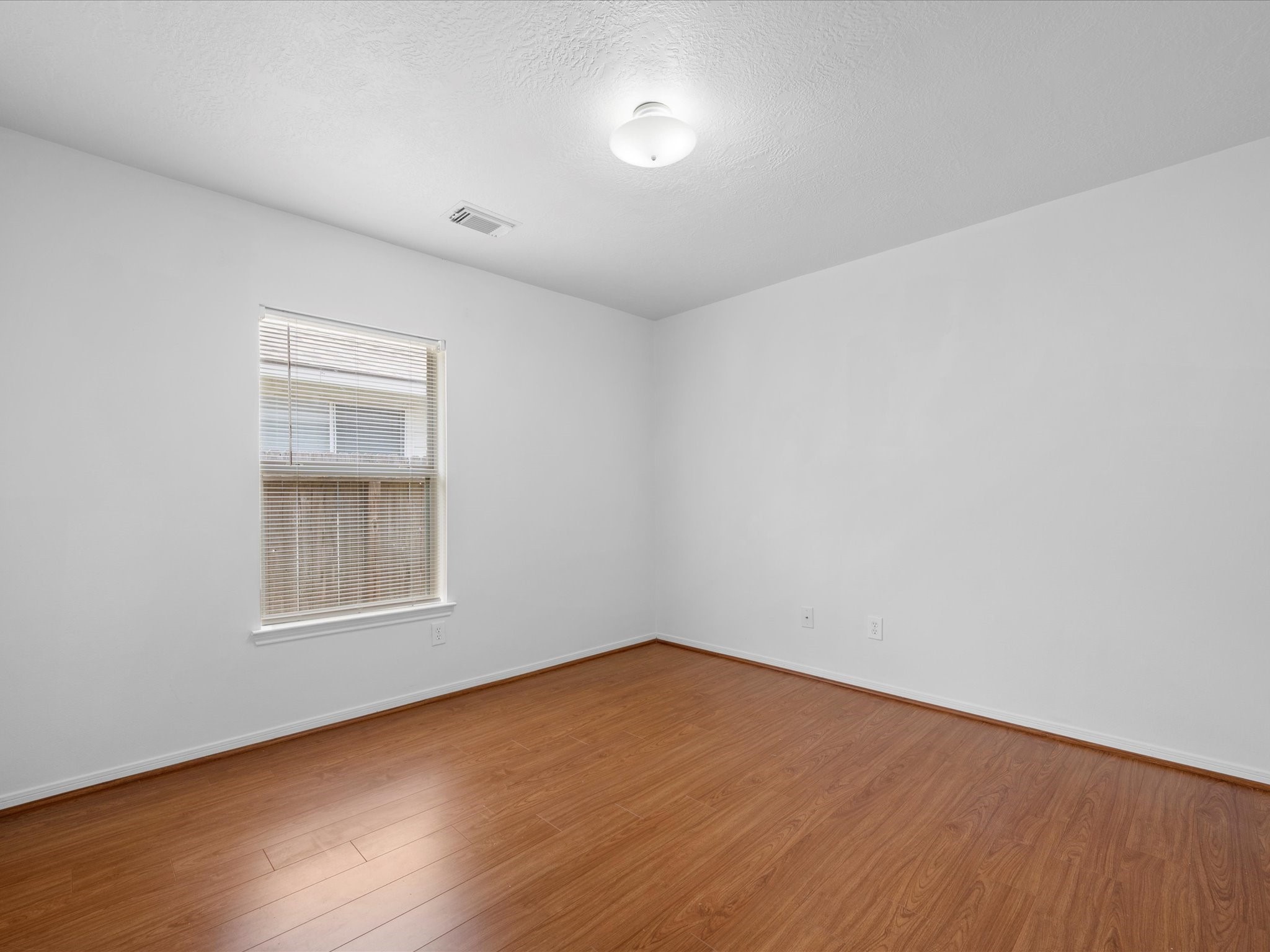 25211 Bluma Ranch Drive Katy, TX 77494 - Photo 19 of 22 an empty room with wooden floor and windows