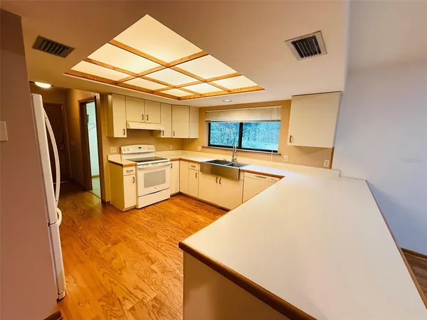 a kitchen with stainless steel appliances granite countertop a sink a stove and a refrigerator