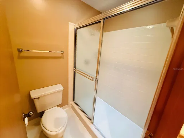 a white toilet sitting next to a shower