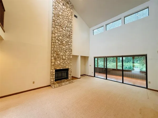 a view of an empty room with a fireplace and a window