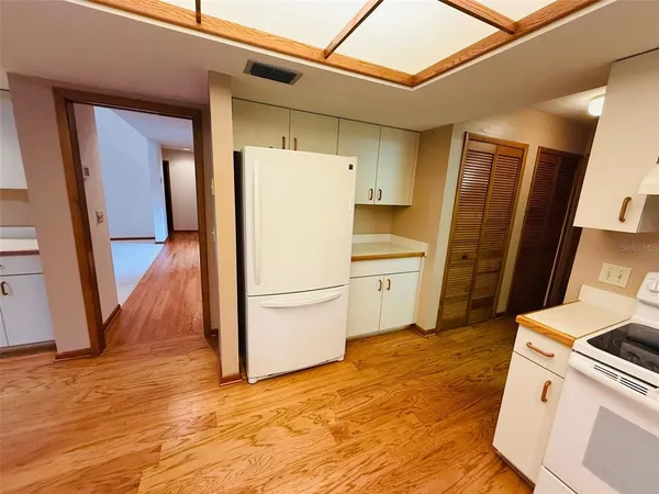 a kitchen with a refrigerator sink and wooden floor