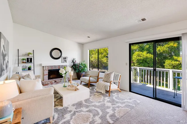 a living room with fireplace furniture and a large window