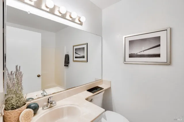 a bathroom with a toilet sink and mirror