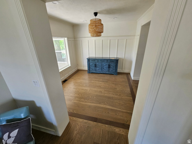 812 East Bates Cyn Road Tooele, UT 84074 - Photo 16 of 144 Spacious room featuring wood-finish flooring with a contrasting border, board and batten wall paneling, a large window, and a woven pendant light fixture