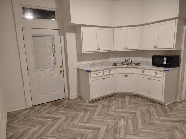 a kitchen with white cabinets and white appliances