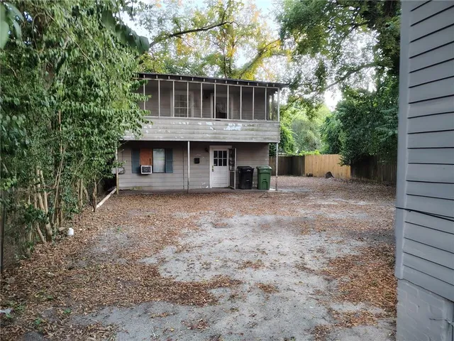 a view of a house with a yard and large tree