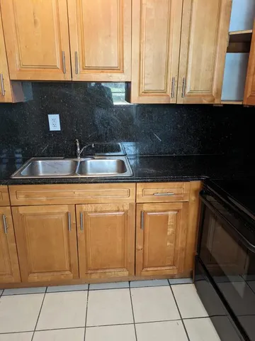 a kitchen with white cabinets and black appliances