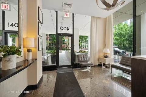 a view of a hallway with wooden floor and a bathroom