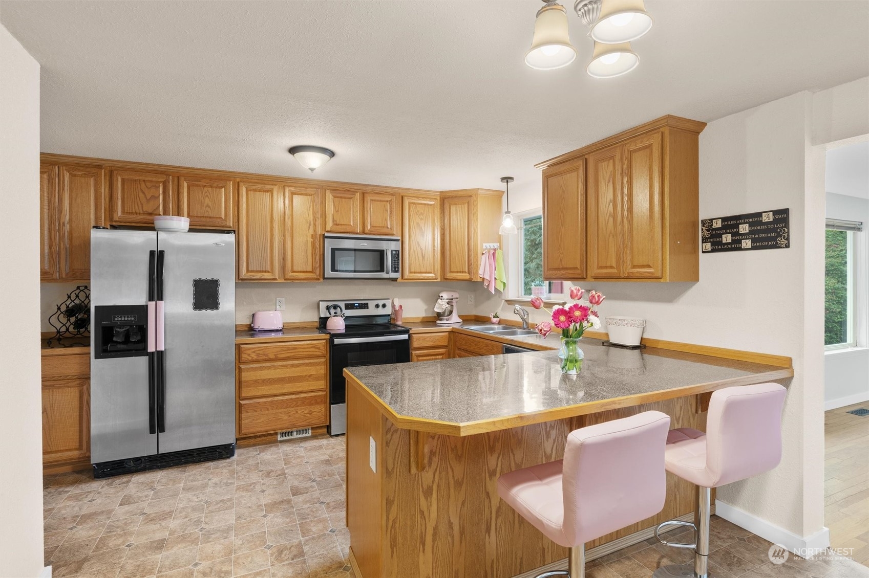 17545 Southeast 134th Street Renton, WA 98059 - Photo 6 of 40 a kitchen with stainless steel appliances granite countertop a stove refrigerator a microwave oven a sink dishwasher and wooden cabinets
