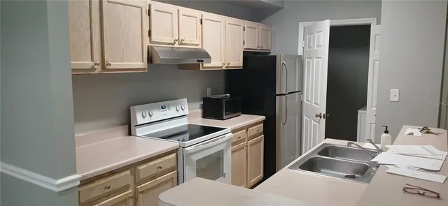 a kitchen with stainless steel appliances a stove a refrigerator and cabinets