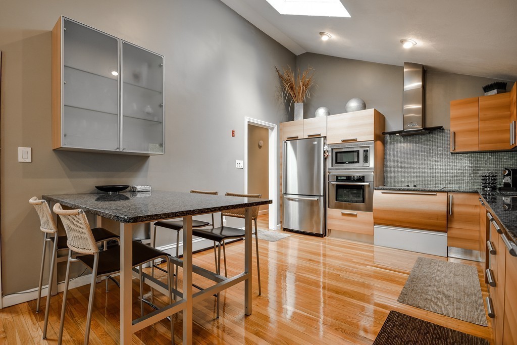 20 Rutledge Road Natick, MA 01760 - Photo 5 of 29 a kitchen with stainless steel appliances kitchen island granite countertop a table chairs stove and refrigerator