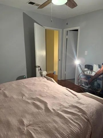 a bedroom with a bed and a ceiling fan