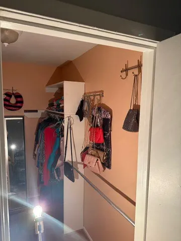a view of walk in closet with clothes and shoes