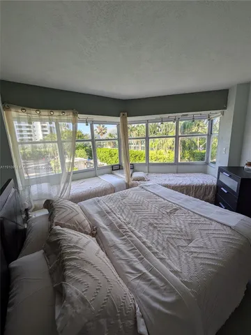 a large bedroom with a bed and a large window