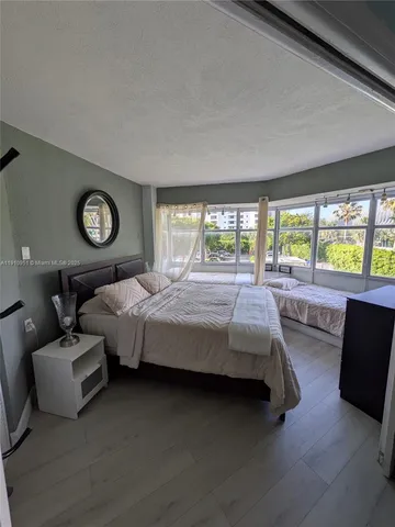 a bedroom with furniture and a large window