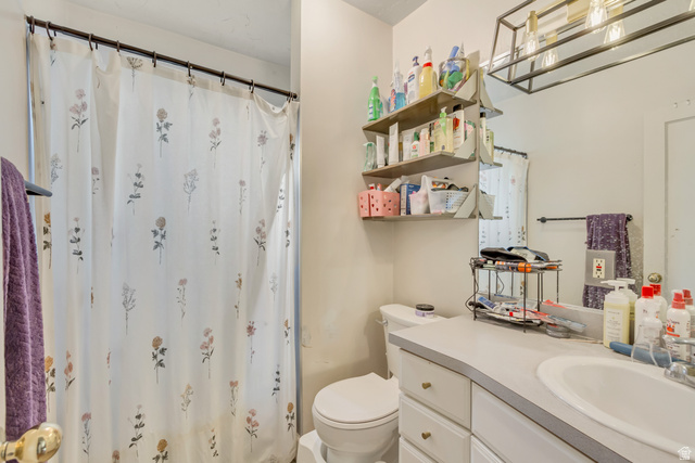 65 West 700 North Bountiful, UT 84010 - Photo 18 of 29 Bathroom featuring a built-in vanity with a white basin sink, framed mirror, and overhead linear light fixture