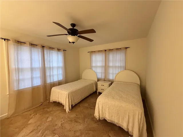 a spacious bedroom with two bed and window
