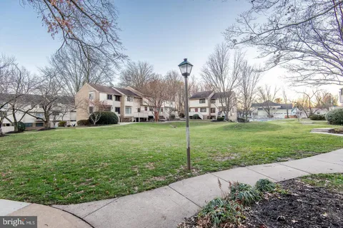 a white house with a big yard plants and trees