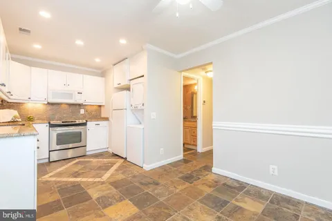 a kitchen with granite countertop a refrigerator and a stove top oven