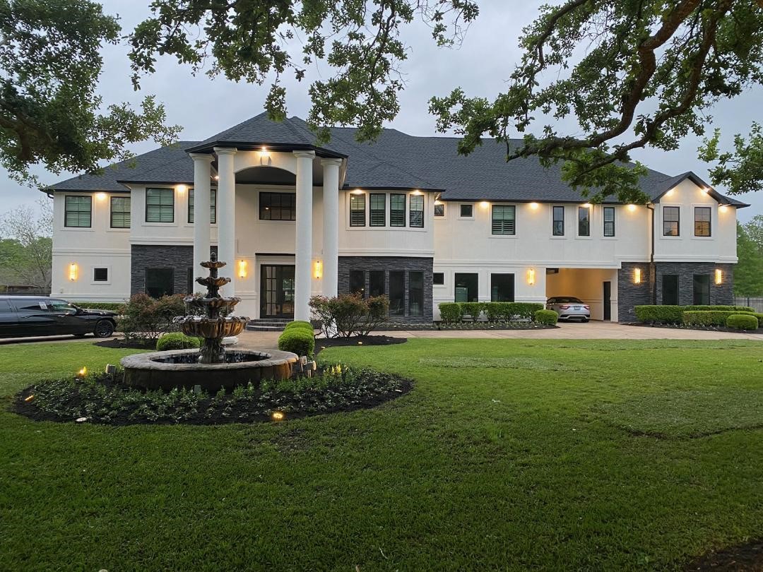 4002 Silver Ridge Boulevard Missouri City, TX 77459 - Photo 1 of 50 Elegant two-story home with a grand entrance, featuring a stately fountain in the front yard, well-appointed lighting, and a sizable driveway. The exterior is finished with a mix of white and dark contrasting elements, offering a modern and luxurious appeal.