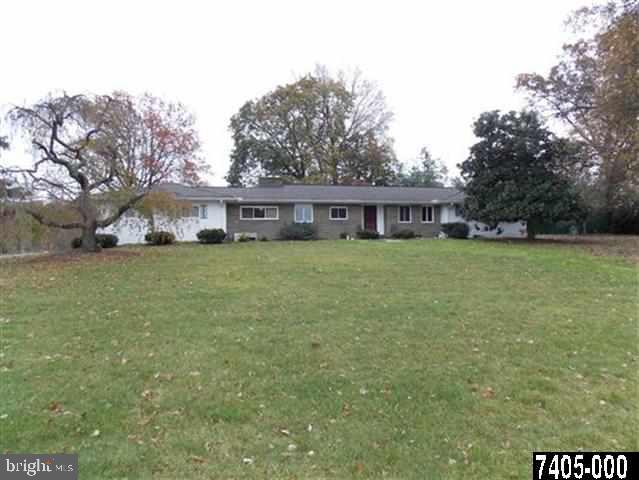 a view of a house with a yard and sitting area