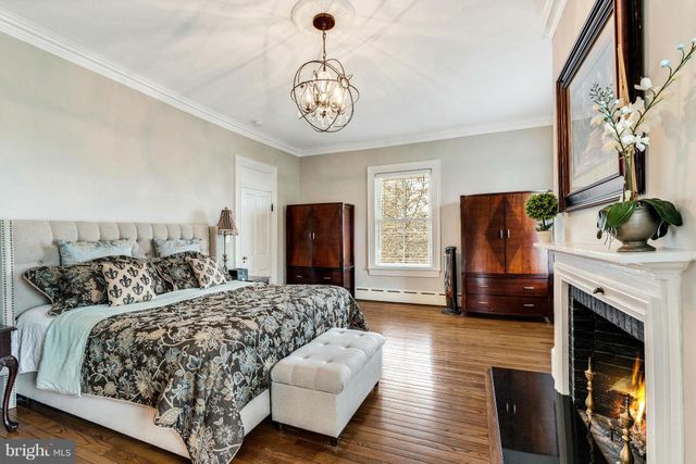 a bedroom with a bed a fireplace and a television