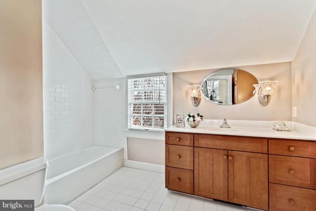 a bathroom with a tub sink and mirror