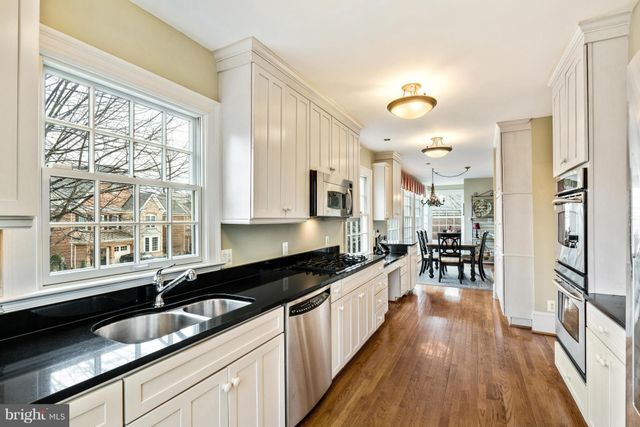 a large kitchen with granite countertop a large window and stainless steel appliances