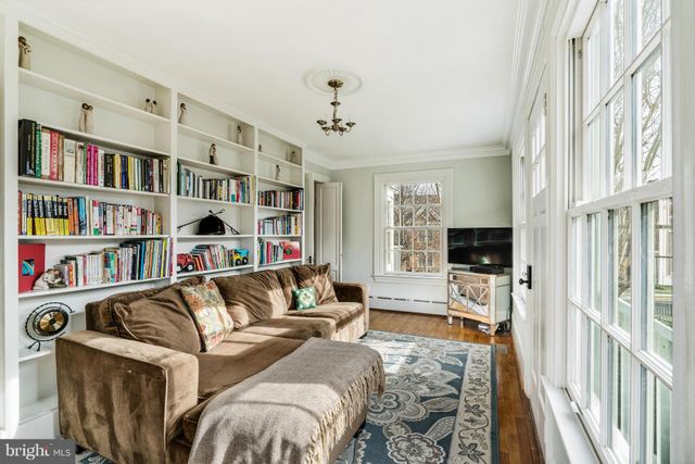a living room with furniture a rug and a book shelf