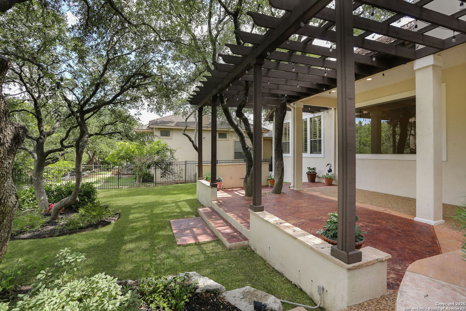 24630 Bogey Ridge San Antonio, TX 78260 - Photo 6 of 50 a view of a patio with table and chairs potted plants and large tree