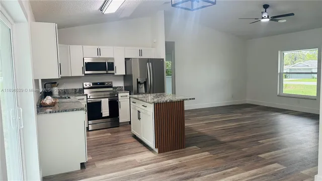 a kitchen with stainless steel appliances a stove top oven a sink and a refrigerator