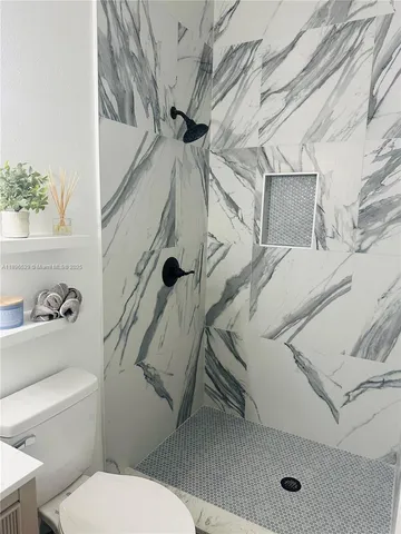 a white toilet sitting next to a bathroom sink