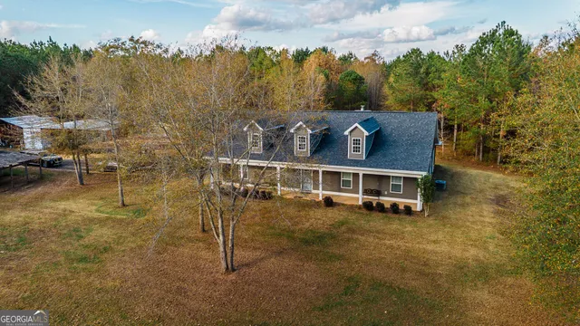 an aerial view of a house with a yard basket ball court and outdoor seating