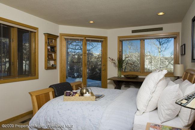 135 North Ridge Lane Snowmass Village, CO 81615 - Photo 4 of 8 a bedroom with a bed and glass windows