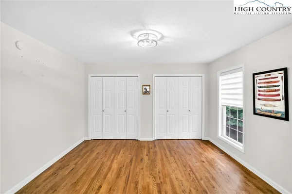 a view of a room with wooden floor and a window