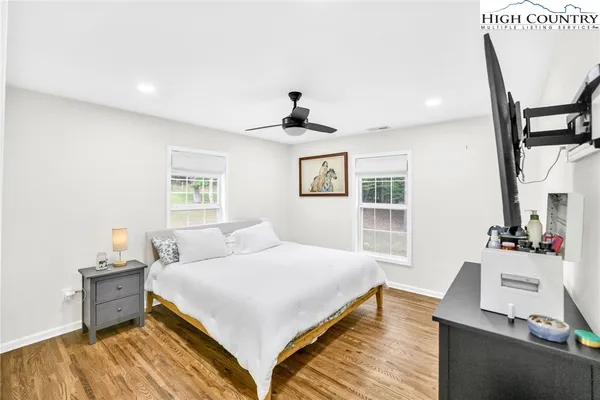 a bedroom with a bed and wooden floor