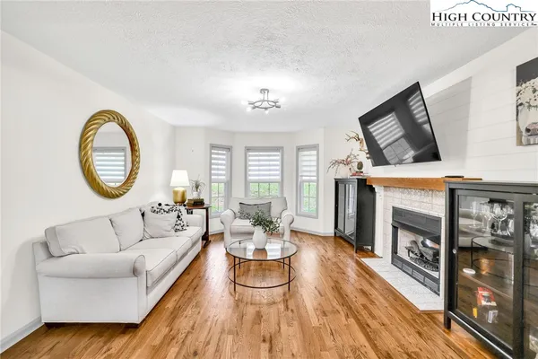 a living room with fireplace furniture and a wooden floor