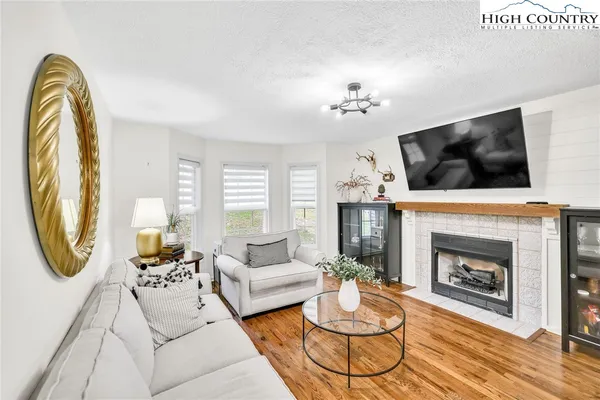 a living room with furniture a fireplace and a flat screen tv
