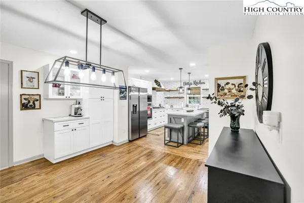 a living room with stainless steel appliances kitchen island granite countertop furniture a rug kitchen and a sink